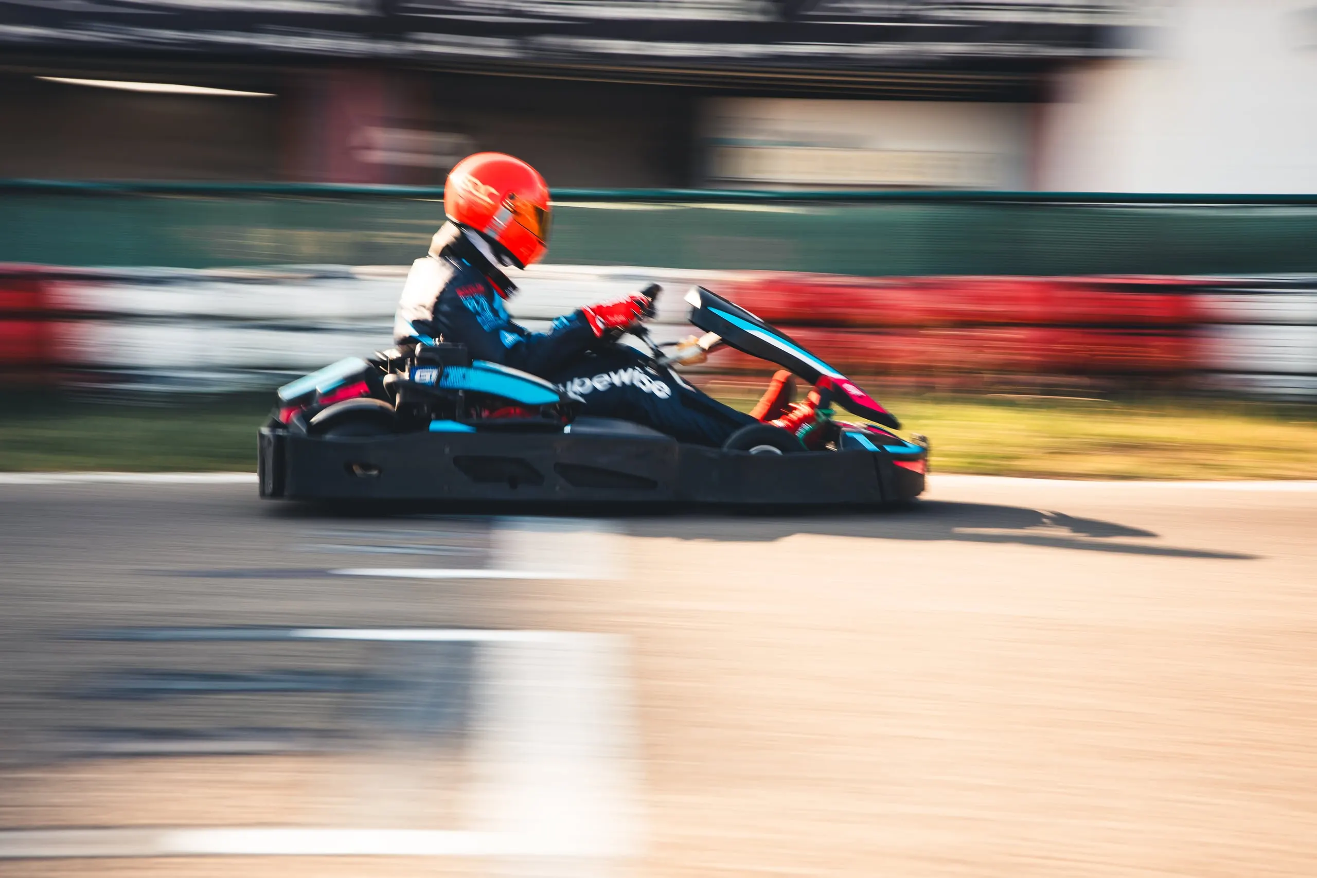 Kart em movimento no Kartódromo, piloto com capacete vermelho